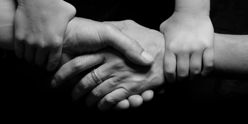 Child Holding Parents Hands Together