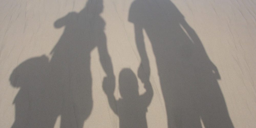 Shadow of parents holding hand with child