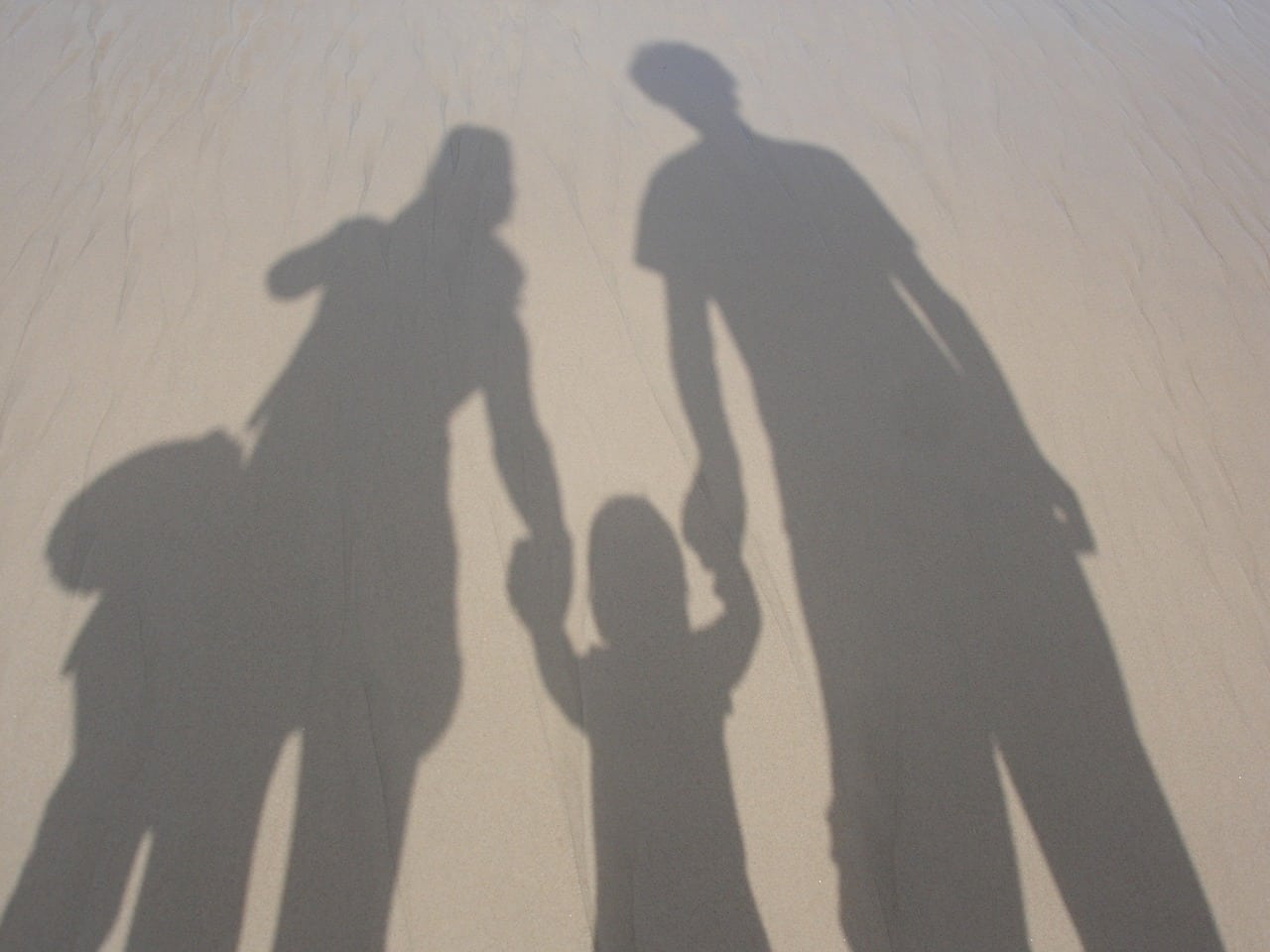 Shadow of parents holding hand with child