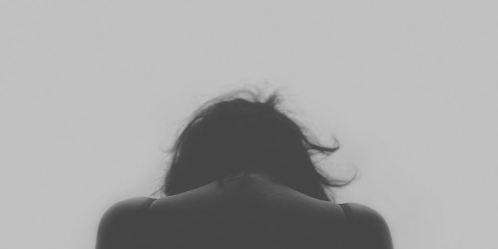Black and white photo of woman with head down