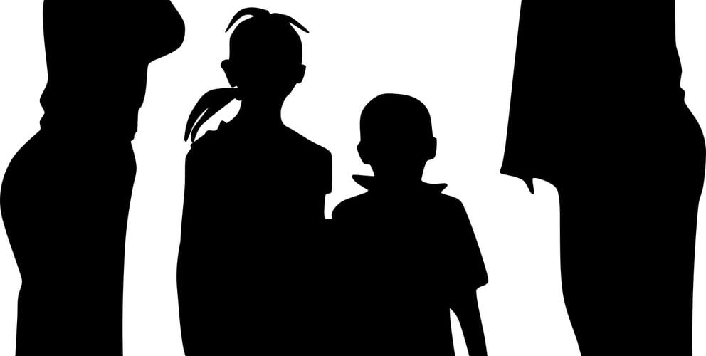 silhouette of a adults holding hands above the head of two children