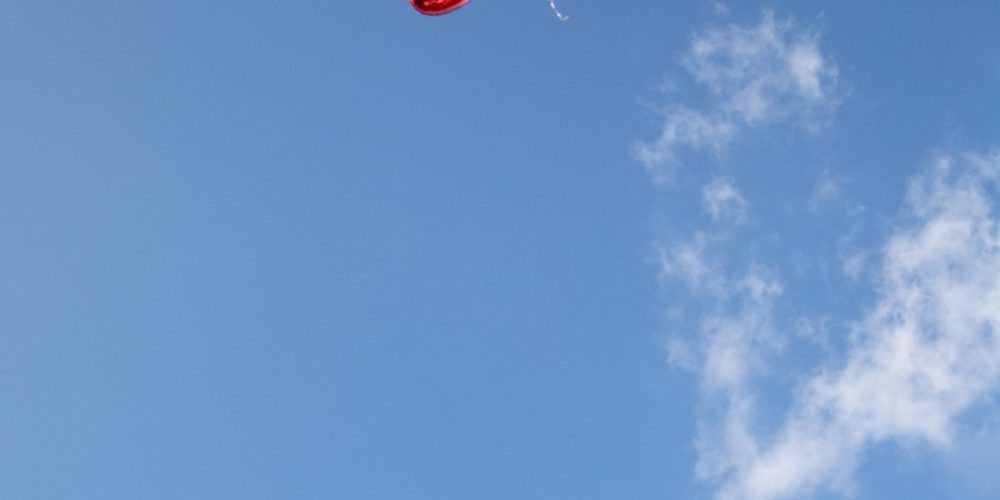 Heart ballon floating into the sky