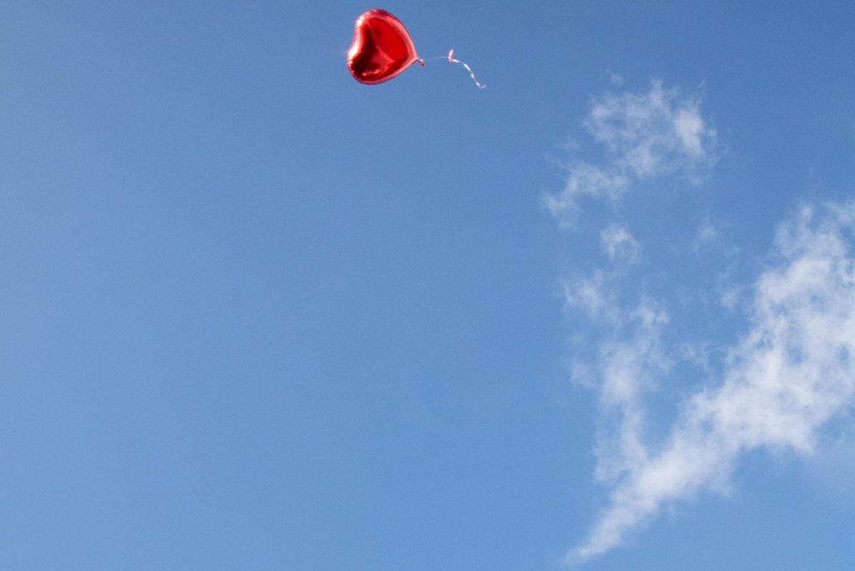 Heart ballon floating into the sky